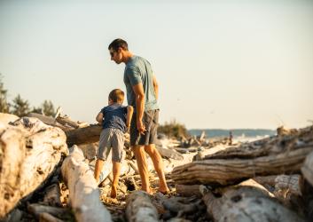 Man and child looking for something on the beach.